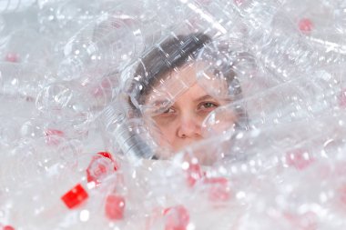 Çevre Koruma, insanlar ve geri dönüştürülebilir plastik kavram - bir yığın plastik şişe oturan çevre felaketi ile ilgili yorgun kadın