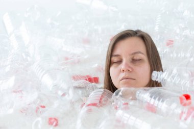Çevre Koruma, insanlar ve geri dönüştürülebilir plastik kavram - bir yığın plastik şişe oturan çevre felaketi ile ilgili yorgun kadın