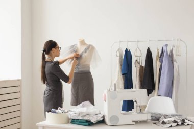 İnsanlar ve moda kavramı - Back view manken ofis malzemeleri ölçme şık kıyafeti giymiş moda dükkanı sahibi