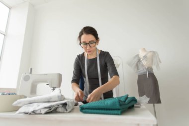 Terzi, moda tasarımcısı, terzi ve insanlar kavramı - iş yerinde bir kadın terzi portresi