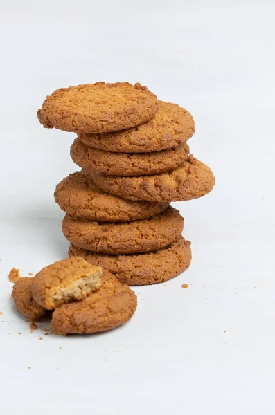 Stack of oatmeal cookies lies on a white table. Concept of low-calorie desserts and a healthy snack. Sweet culinary.