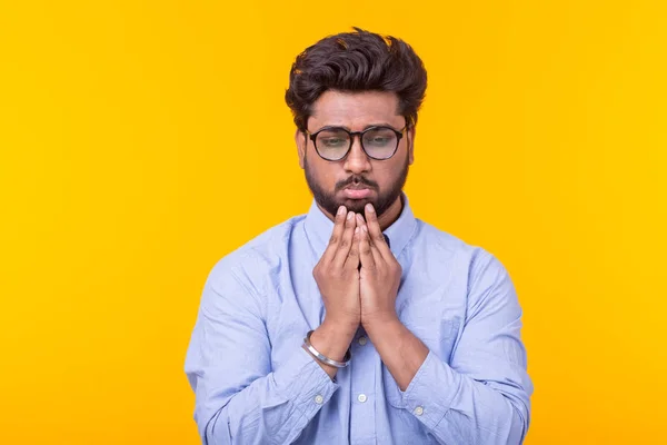 Empresário indiano em roupas formais está olhando para baixo pensativo posando em um fundo amarelo. Conceito de perda e problemas no negócio . — Fotografia de Stock