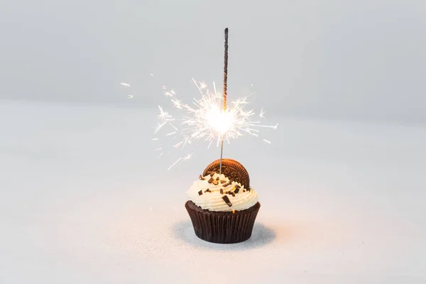 Cibo, festa e concetto di vacanza - Cupcake di compleanno con sparkler su sfondo bianco — Foto Stock