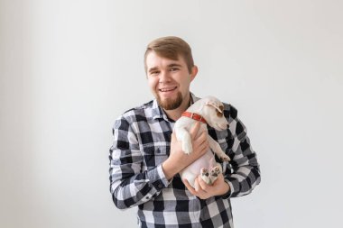 insanlar, Evcil hayvanlar ve hayvanlar kavramı - yakışıklı adam tutarak jack russell terrier yavru beyaz arka plan üzerinde