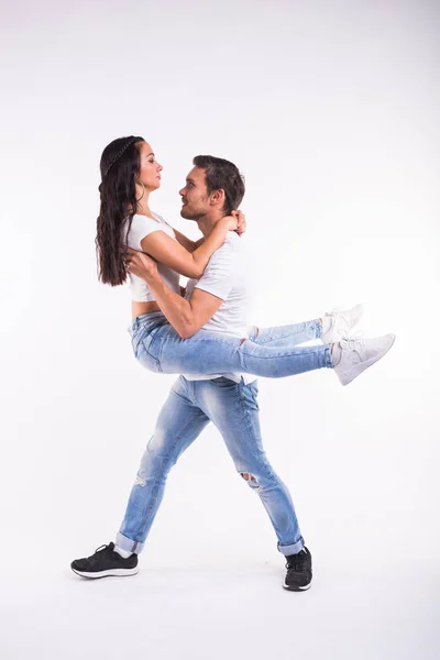Giovane coppia che balla bachata di danza sociale, merengue, salsa, kizomba. Due posa eleganza sulla stanza bianca . — Foto Stock