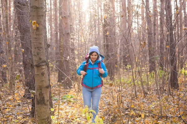 People, hike and nature concept - Female tourist walking in the autumn forest — Stock Photo, Image