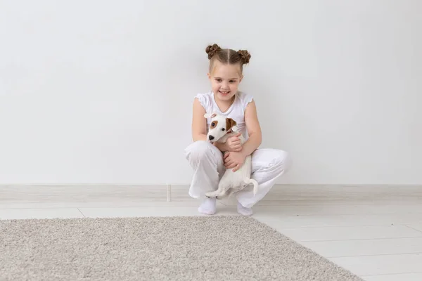 Perros, mascotas y concepto animal - Niña sentada con el cachorro Jack Russell Terrier — Foto de Stock