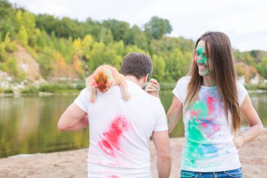 Festival holi, tatil, turizm ve doğa kavramı - çift kedi holding beyaz gömlek giymiş ve renkli tozla kaplı