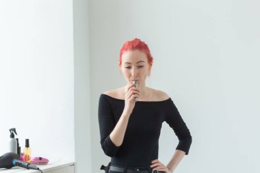 Gençlik ve bağımlılık kavramı - genç kızıl saçlı kadın pencere yakınında vape sigara