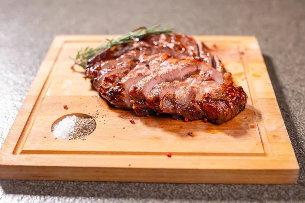 Food, delicious and craft concept - cutting horse meat steak on wooden desk — Stock Photo, Image