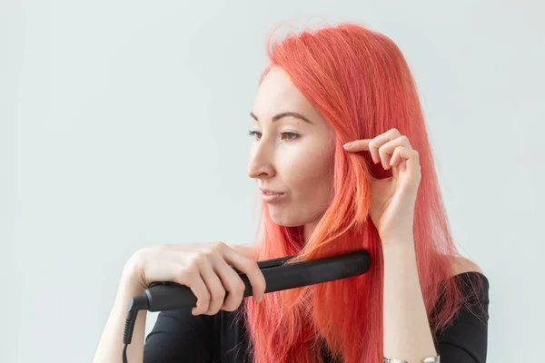 Estilo, moda, cabeleireiro e conceito de pessoas - mulher ruiva elegante com ferro de ondulação no fundo branco — Fotografia de Stock