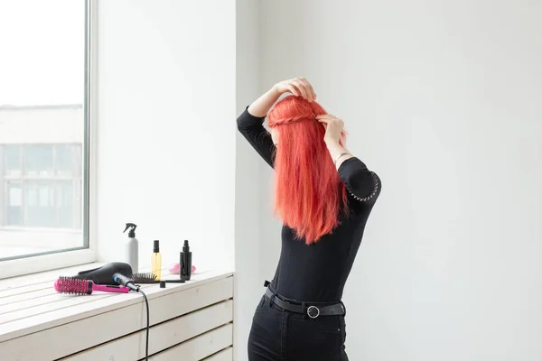 Красивая рыжая девушка с длинными волосами, она плетет косу, в салоне красоты. Профессиональный уход за волосами . — стоковое фото
