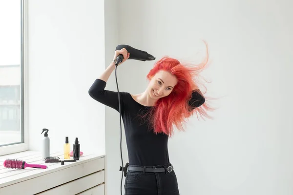 Peluquería, salón de belleza y el concepto de la gente - estilista mujer joven con secador de pelo sobre fondo blanco — Foto de Stock