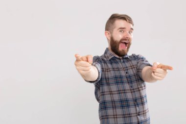 Kopya alanı ile beyaz arka plan üzerinde kamera üzerinde gösteren heyecanlı öğrenci adam