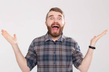 Sarı bir arka planda poz verirken bir bıyık ve gözlük ile sakal ile bewildered genç hipster adam kameraya sürpriz görünüyor. Sürpriz ve komik kavramı.