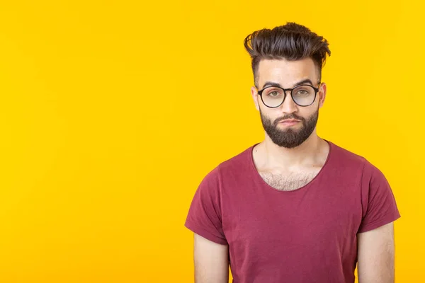 一个英俊的阿拉伯年轻男学生的肖像,穿着酒红色衬衫,在黄色背景上摆出复制空间。年轻人的机会概念 — 图库照片