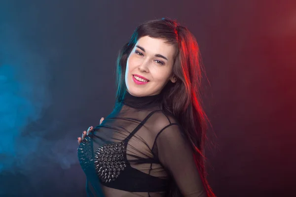 Verführerische junge schöne brünette Frau in einem provokanten Kleid posiert auf einem dunklen Hintergrund. Konzept der Verführung und sexuellen Attraktivität. — Stockfoto