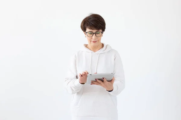 Gyönyörű nő 50 éves, rövid haj gazdaság tabletta fehér háttérrel és másolási tér — Stock Fotó