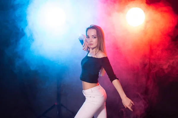 Concepto de danza, gracia y elegancia: mujer joven bailando el estilo de dama bachata en la oscuridad, luces y humo —  Fotos de Stock