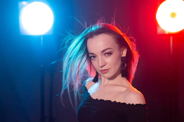 Nightclub, nightlife and people concept - Young woman posing in the dark — Stock Photo, Image