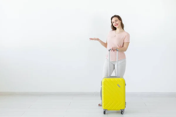 Concepto de viaje, viaje y vacaciones: mujer con su maleta amarilla en el espacio de copia — Foto de Stock
