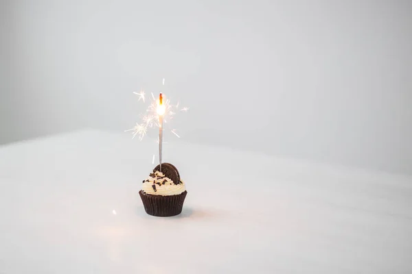 Comida, vacaciones, feliz cumpleaños, panadería y postre concepto delicioso cupcake con espumoso en la mesa blanca con espacio para copiar —  Fotos de Stock