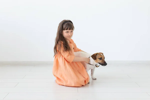 Barn och husdjur ägare Concept-liten barnflicka sitter på golvet med söt valp Jack Russell Terrier — Stockfoto