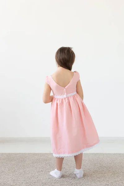Projektant mody, dzieci i koncepcja dziecka-widok z tyłu małej dziewczynki pozowanie w ubraniach w Studio — Zdjęcie stockowe