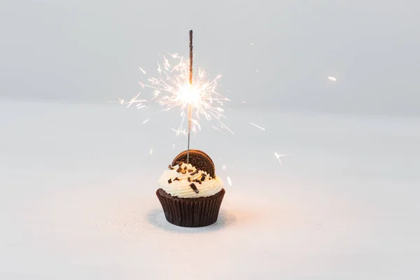 食物, 面包店, 节日, 生日快乐和甜点的概念-美味的纸杯蛋糕与火花和饼干在白色的桌子上 — 图库照片