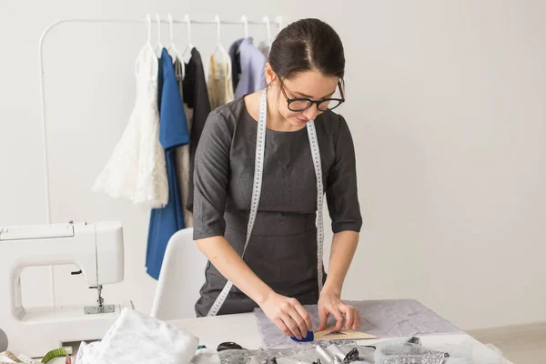 Dressmaker, diseñador de moda y el concepto de sastrería hermosa joven estilista en el lugar de trabajo cerca de rack con ropa — Foto de Stock