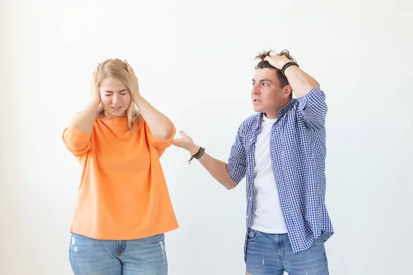 Jonge hipster kerel schreeuwd het verhogen van zijn handen tot zijn geliefde meisje op een witte achtergrond. Concept van slechte relaties en familiale afbraak. — Stockfoto