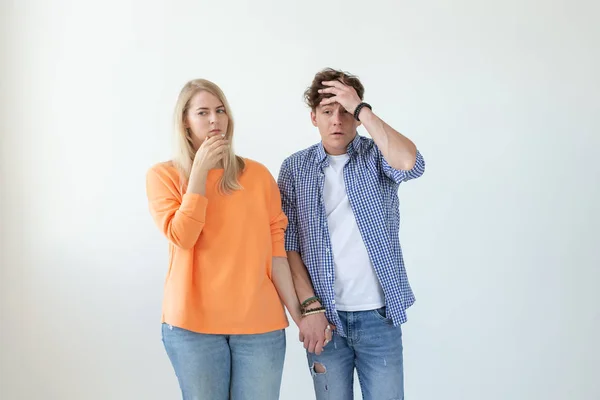 Giovane coppia di studenti scontento fidanzato e stanco giovane fidanzata in posa su uno sfondo bianco che si tiene per mano. Concetto di crisi nelle relazioni e l'aiuto di uno psicologo . — Foto Stock