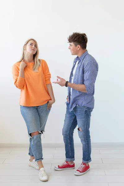 Portrait d'un jeune couple positif gai en pleine croissance vêtu de vêtements décontractés posant sur un fond blanc. Concept de jeunes gens modernes élégants . — Photo