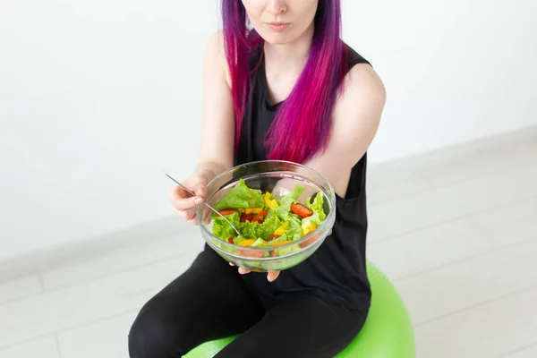 Vue du dessus de la jeune fille hipster asiatique en gros plan qui mange une salade de légumes légers après une séance d'entraînement à la maison. Concept de perte de poids et mode de vie sain . — Photo