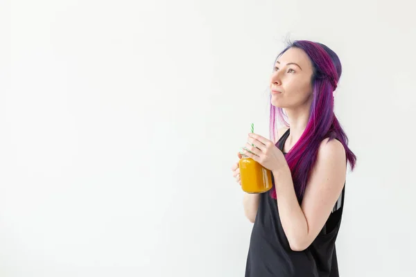 Menina bonito jovem hipster de raça mista com cabelos coloridos bebe smoothie fruta antes de iniciar uma aula de ioga em um fundo branco com espaço de cópia. Conceito de estilo de vida saudável. Copyspase . — Fotografia de Stock