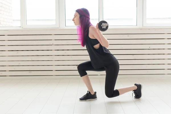 Fitness, deporte, concepto de personas - mujer joven en traje deportivo está en cuclillas con bar — Foto de Stock