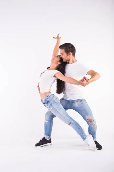 Pareja joven bailando baile social latino bachata, merengue, salsa. Dos poses de elegancia sobre fondo blanco — Foto de Stock