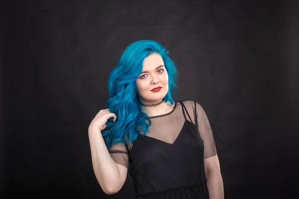 Pessoas e conceito de moda - Mulher jovem e atraente com batom preto e cabelo azul posando sobre fundo preto — Fotografia de Stock