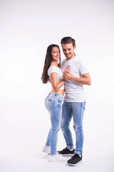 Young couple dancing social dance bachata, merengue, salsa, kizomba. Two elegance pose on white room.