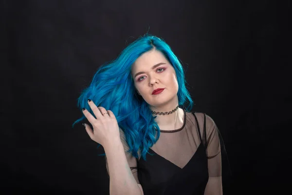 Koncepce stylu a módy-mladá a atraktivní žena s modrými vlasy pózlivými přes černé pozadí — Stock fotografie