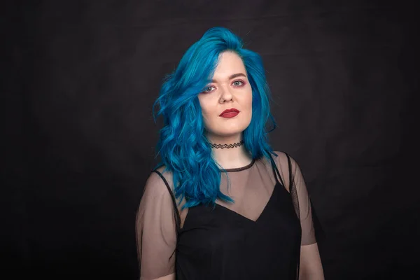 Lidé, móda a vlasový koncept-blízký portrét mladé ženy v černých šatech s modrými vlasy na černém pozadí — Stock fotografie