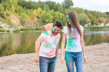 Evde beslenen hayvan, yaz turizm, festival holi ve doğa kavramı - komik erkek ve kadın ile kedi doğal zemin üzerine