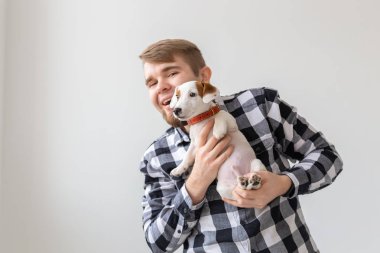 Kişi, evde beslenen hayvan ve köpek kavramı - beyaz arka plan holding köpek yavrusu Jack Russell Terrier gülümseyen adam