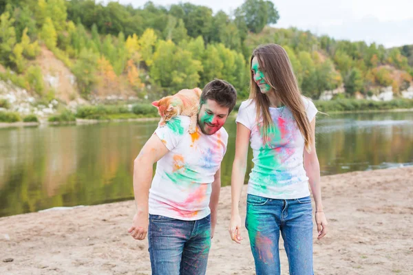 Evde beslenen hayvan, yaz turizm, festival holi ve doğa kavramı - komik erkek ve kadın ile kedi doğal zemin üzerine