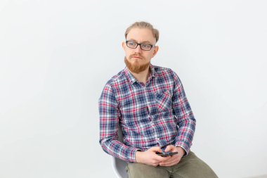 Genç sakallı hipster adam beyaz arka plan üzerinde cep telefonu tutan