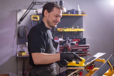 Onarım, servis ve insan kavramı - bir parafin sürtünme tarafından kayak tamir bir adam