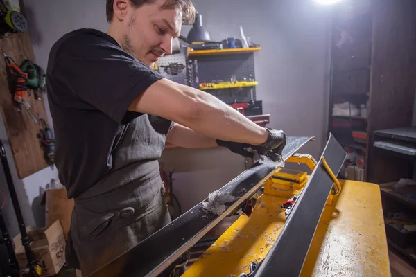 Un hombre reparador en el servicio de esquí taller reparando el esquí — Foto de Stock