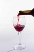 Láhev na červené víno nalévat sklo na bílém pozadí
