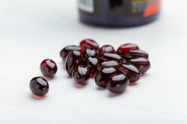 Beyaz masa arka planında kırmızı haplar. Vitamin ve mikroelementlerin ilaç kavramı. Tedavi ve önleme.