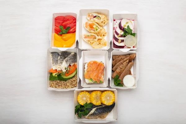 Set of healthy meals for the day in lunch boxes stands on a white table. Concept of menu of proper nutrition is the balance of proteins, fats and carbohydrates